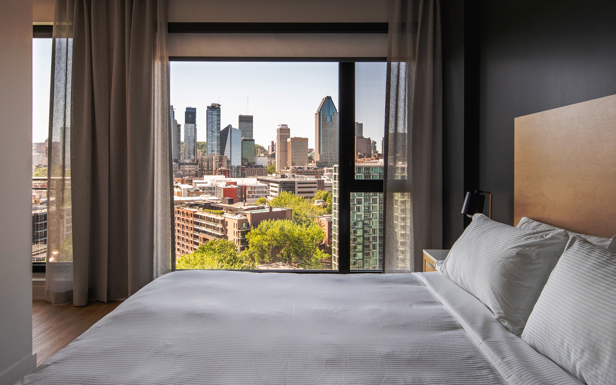 Griffintown Hotel bedroom with floor-to-ceiling window over the Montreal skyline